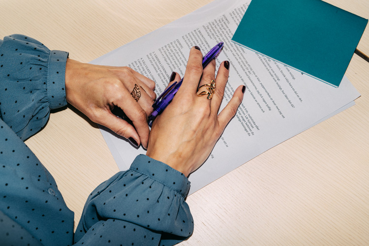 En person skriver på ett avtal. 